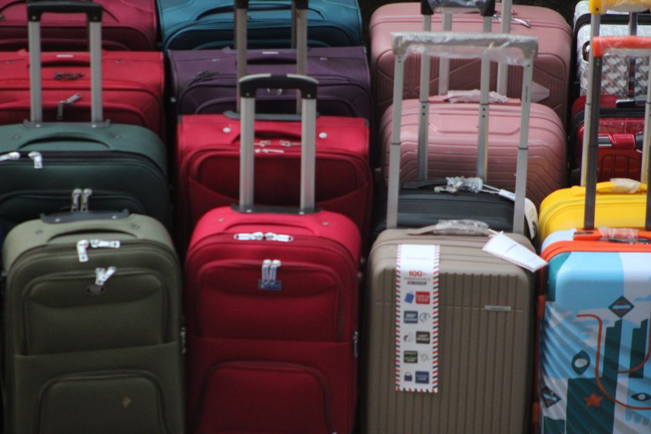 An open suitcase being packed with clothes and small gifts before a flight